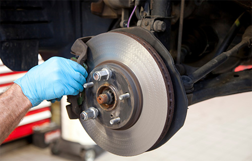 Hands smoothing car brakes during brake service in Safety Harbor