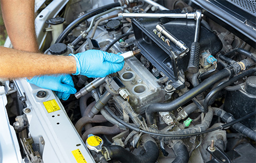 Gloved hands checking a car engine in Seminole