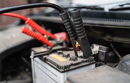 A red clamp and black clamp attached to a car battery