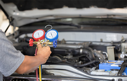 Mechanical gauges are hooked up to a car at a shop for auto repair in Seminole