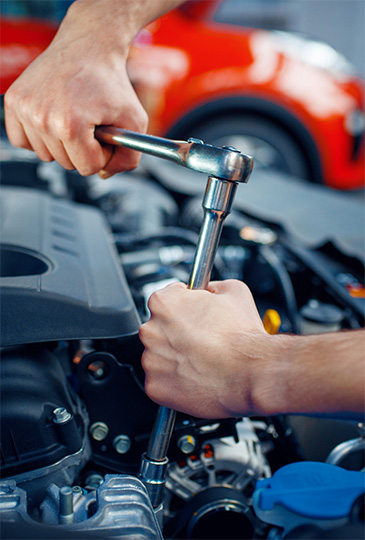 Hands tune up an engine during auto care services in Seminole, FL