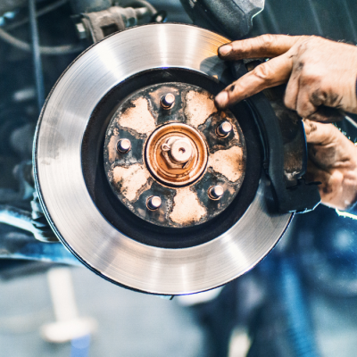 Hands clean car brakes after brake service in Seminole